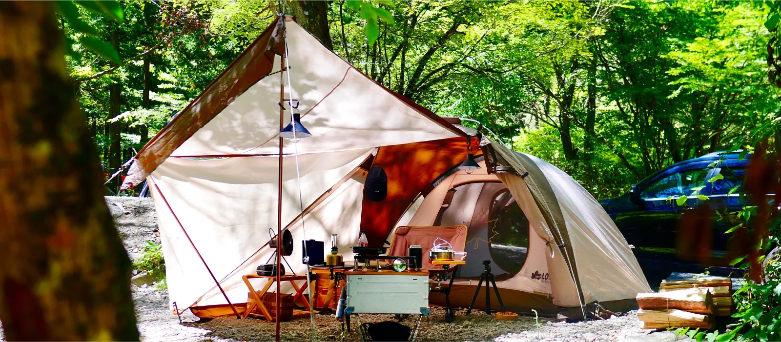 画像：自然の中でテントをはりキャンプをしている。